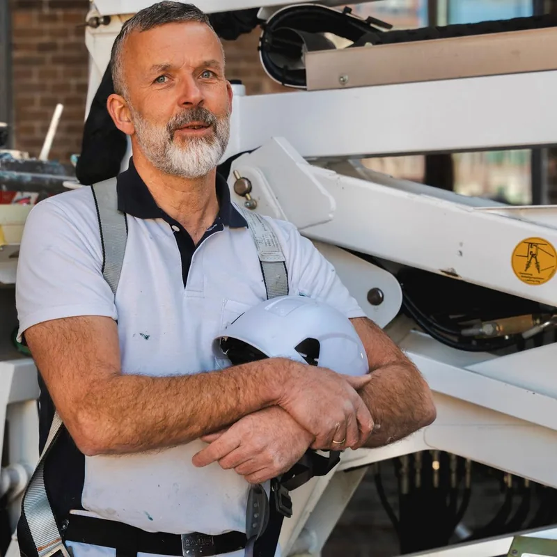 Vincent van Wijk op de hoogwerker bij het schilderwerk